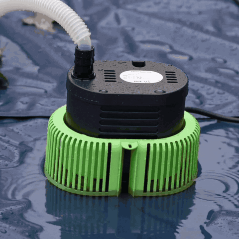 Baxvo automatic pool cover pump removing standing water from a pool cover, with water flowing from the discharge hose.